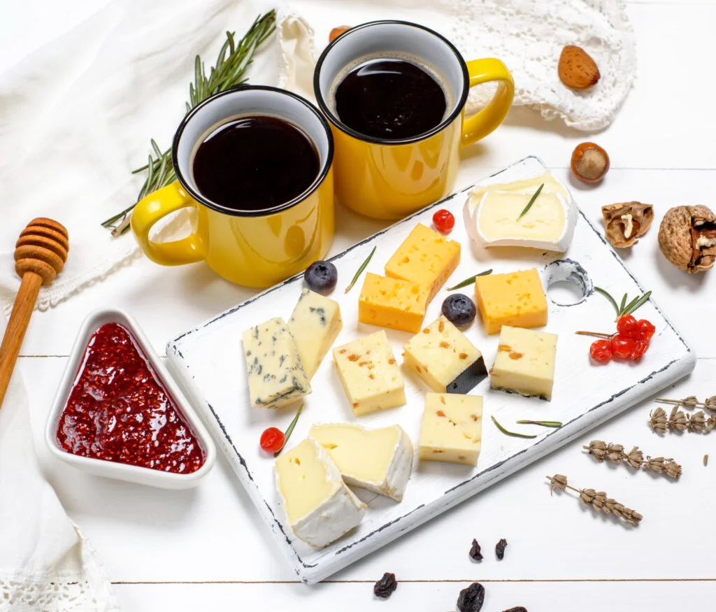 pieces of cheese on a white wooden board